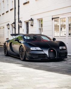 a black bugatti parked in front of a white building