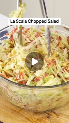 a glass bowl filled with coleslaw on top of a wooden table