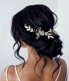 the back of a woman's head wearing a hair comb with flowers and leaves on it