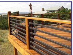 a man standing on top of a wooden deck next to a metal rail and railing