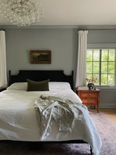 a bedroom with a large bed and chandelier