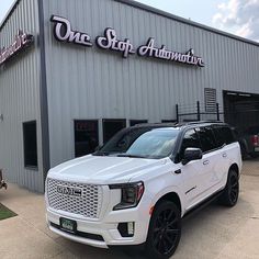 a white suv parked in front of a building