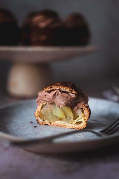 a piece of bread with chocolate frosting and apples on it next to a fork