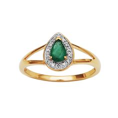 a gold ring with a pear shaped emerald and diamonds