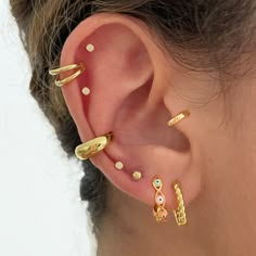 a close up of a person's ear with different types of jewelry on it