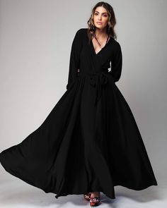 This 70's inspired maxi dress features a sexy cross front V-shaped surplice neckline. The elasticized waist adjusts to fit a range of sizes and has an attached self-tying belt at the right-hand side seam. The cuffed bell sleeves add a hint of retro glamour. The opaque fabric has a butter-soft hand with a gorgeous deep, jet black hue. The full, sweeping circle mid-length skirt is perfect for making a dramatic entrance to any event. The skirt is partially lined. DetailsBrand: Meghan LAColor: Black Circle Maxi Skirt, Retro Glamour, Black Slip Dress, Fashion District, Medium Dress, Mid Length Skirts, 70s Inspired, Independent Designers Fashion, Black Maxi Dress