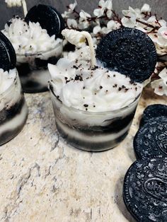 oreo cookies and ice cream in glasses on a marble counter top with white flowers