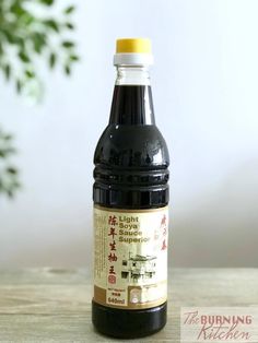 a bottle of black sauce sitting on top of a wooden table