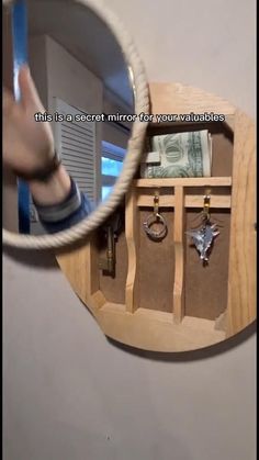 a mirror that is hanging on the side of a wall with keys and money in it