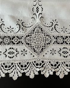 an embroidered white cloth with black lace on it