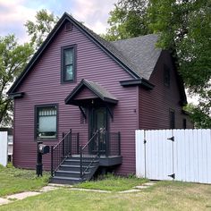 a purple house with a white picket fence