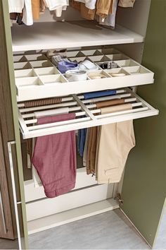 an organized closet with clothes hanging on rails