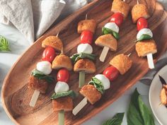 several skewers of food on a wooden platter