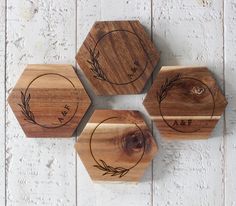 four wooden coasters with engraved designs on them