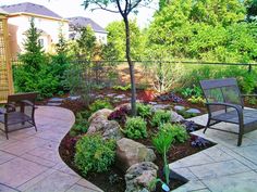 an outdoor patio area with stone walkway and seating areas in the back yard, surrounded by trees