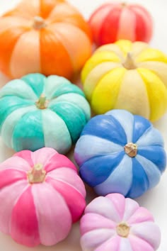 colorful pumpkins are arranged on a white surface