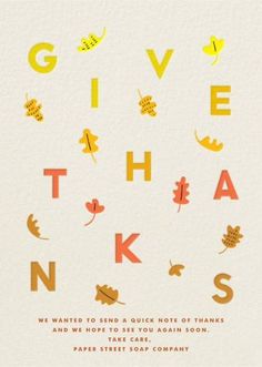 the words give thanks written in orange, yellow and red on white paper with leaves