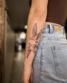 a woman's arm with a bird tattoo on the left side of her body