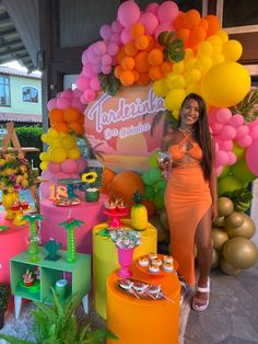 a woman standing in front of a bunch of balloons