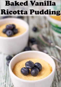 two small white bowls filled with baked vanilla ricotta pudding and blueberries on top