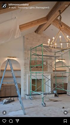 an unfinished room with scaffolding and lights on the ceiling, including a chandelier