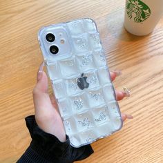 a person holding an iphone case that has many small diamonds on it, with a starbucks cup in the background