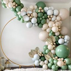 the balloon arch is decorated with green, white and gold balloons in an elegant manner