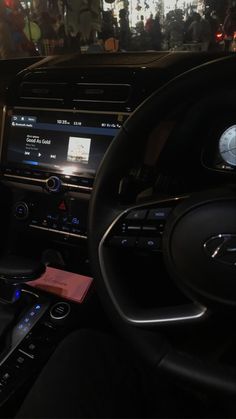 the interior of a car with an entertainment system and steering wheel controls in front of it