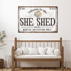 a wooden bench sitting in front of a wall with a sign above it that says she shed