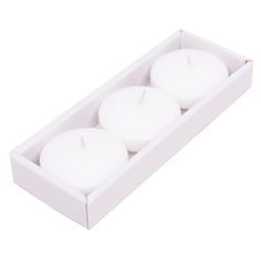 three white candles in a box on a white background