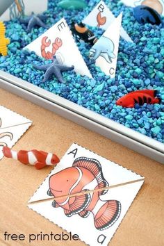 an ocean scene with fish and sea animals on the table, including blue rocks and paper straws