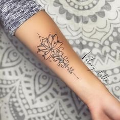 a woman's arm with a flower tattoo on the left side of her arm