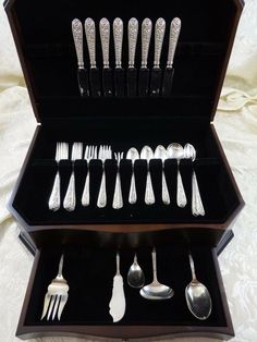 an assortment of silverware in a black case