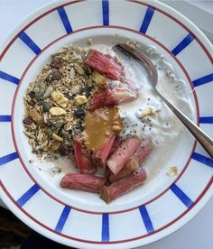 a bowl filled with granola, yogurt and strawberries next to a spoon