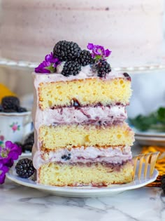 a slice of cake on a plate with blackberries