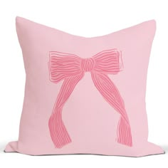 a pink pillow with a bow drawn on the front and back of it, sitting on a white surface