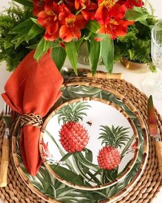 there is a plate with pineapples on it and red flowers in the background