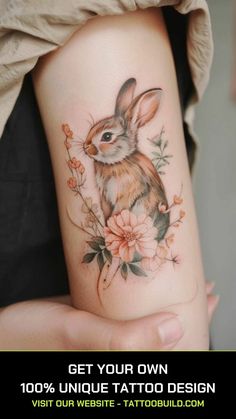 a rabbit tattoo on the arm with flowers and leaves in it's center, which reads get your own 100 % unique tattoo design visit our website - tatoo