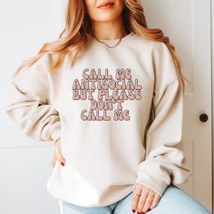 a woman wearing a sweatshirt that says call me antisocial but please don't call me