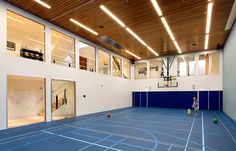 an indoor basketball court with blue and white lines on the floor is pictured in this image