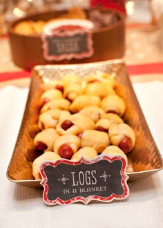 hot dogs and pastries are on display in a buffet style tray at a christmas party