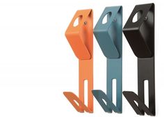 three different colored metal hooks on a white background and one is black, the other has orange