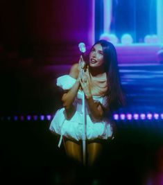 a woman in white dress holding a microphone