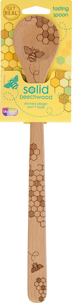 a wooden spatula with bees and honeycombs on the handle, in front of a