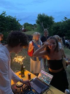 two men and a woman at a party with sparklers in the air behind them