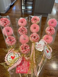 pink donuts with sprinkles are arranged in clear boxes