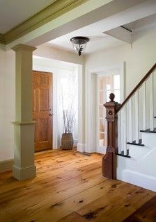 an empty entryway with wooden floors and white walls, along with a staircase leading up to the second floor