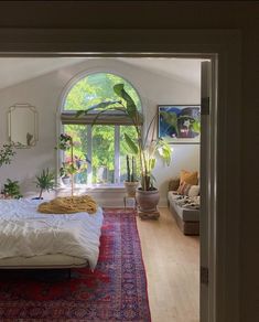 a bedroom with an arched window and rugs on the floor in front of it