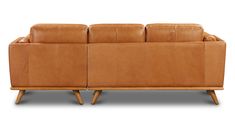 a tan leather couch sitting on top of a wooden frame