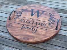 a personalized cutting board on a wooden table with the words, the williams family